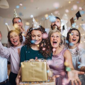 A portrait of multigeneration family with presents on a indoor birthday party.