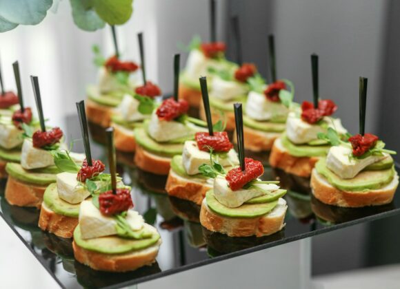 Festive decorated canapes for event with avocado and cheese and dried tomatoes. Eating at the event