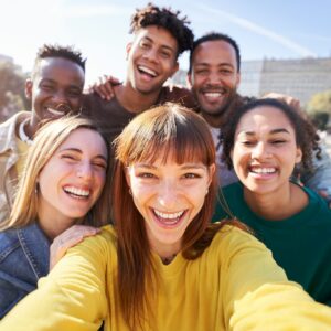 Group of happy friends posing for a selfie on a spring day as they party together outdoors